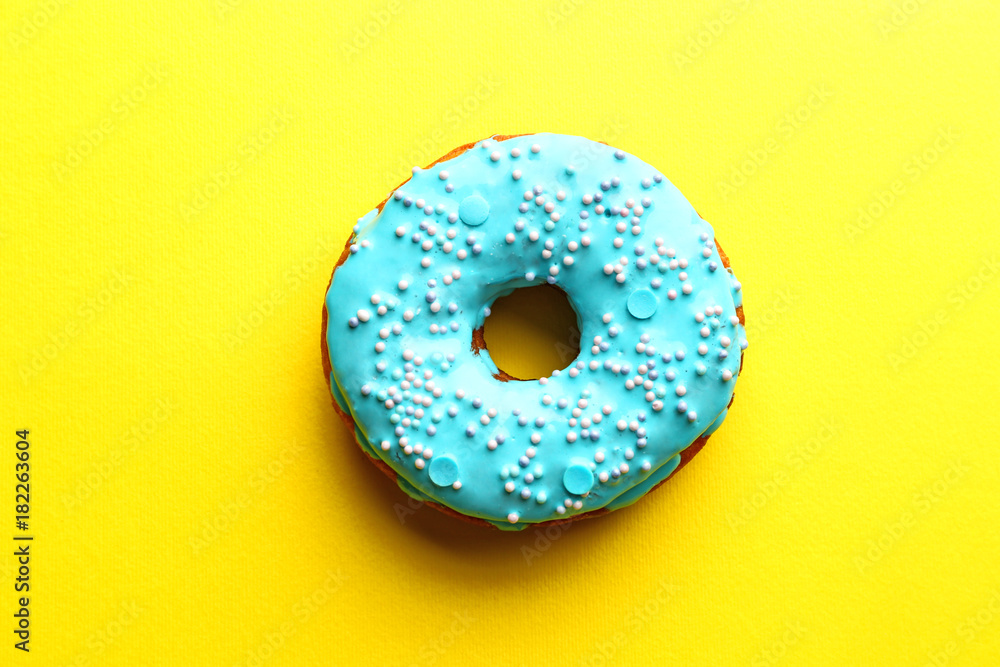 Tasty glazed donut on color background