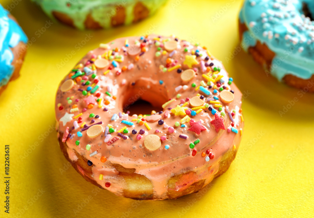 Tasty glazed donut on color background