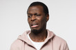 © Damir Khabirov - Disguting! Shocked young african american man looking at something unpleasant and bad, isolated on gray background. Negative emotion concept