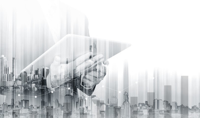Double exposure Businessman working on digital tablet with modern buildings. Business growth and investment