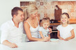 © uv_group - Smiling young parents and their little children daughter are very happy at kitchen home