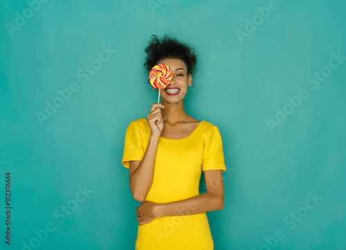 Photographie Happy mulatto girl with lollipop at studio background