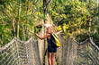 Caraïbes, Martinique, jardin de balata : femme qui traverse un pont suspendu