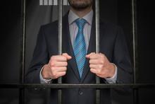 Businessman Or Politician Behind Bars In Prison Cell.