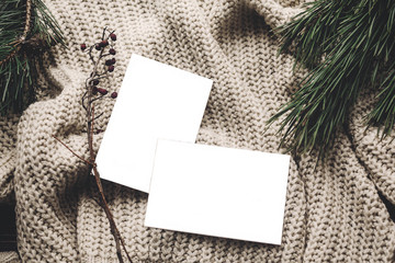 Wall Mural - christmas card mockup. empty christmas card with space for text, template on knitted sweater and fir branches. flat lay, merry christmas, seasonal greetings, happy holidays. atmospheric  moments