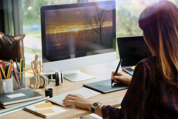 Wall Mural - young hipster graphic designer woman using digital graphic tablet while working at modern office, pr