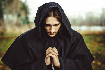 Wall Mural - a monk in robes praying in the woods