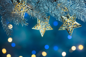 Wall Mural - fir tree branch decorated with garlands on blue background with blurred christmas lights