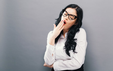 Wall Mural - Young woman yawning on a solid background