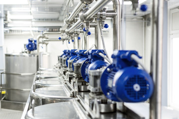 Wall Mural - Rows of blue electric motors on tanks for mixing liquids.