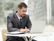 © ASDF - businessman working on laptop while sitting at a table in a coffee