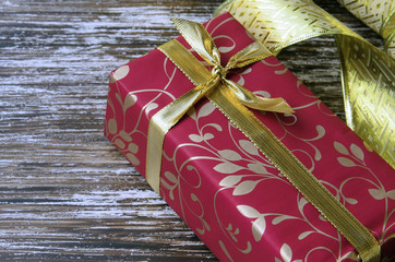 Close up of Red gift box with golden ribbon on wooden background.. Concept for celebration and greeting. Copy space.