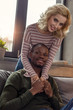© LIGHTFIELD STUDIOS - smiling caucasian woman hugging african american boyfriend on sofa at home