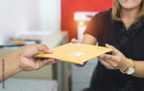 Fotomural male hand send mail envelope to the female of post office before sending