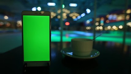 smartphone with green screen on festive in the bokeh lights winter background