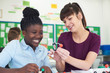 © highwaystarz - Female Pupil And Teacher Using Molecular Model Kit In Science Lesson