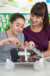 © highwaystarz - Teacher Talking To Female Pupil Studying Robotics In Science Lesson
