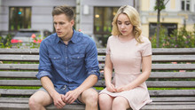 Depressed Boyfriend And Girlfriend Sitting On Bench After Fight, Breaking Up