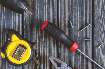 instrument - pliers, screwdriver, screw, tape on blue wooden background