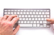 © Patryk Kosmider - Male hands typing on white computer keyboard