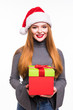 © dianagrytsku - Christmas Santa hat isolated woman portrait hold christmas gift. Smiling happy girl with red hair on white background.