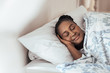 Young African woman fast asleep in her bed at home