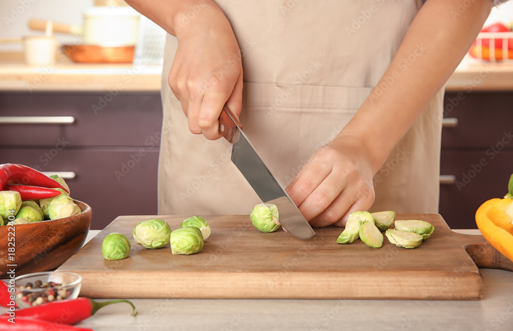 Woman cooking brussels sprouts on table