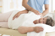 © Photographee.eu - Masseur massaging senior woman's shoulders