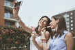 © chika_milan - Two girls taking selfie while eating ice cream outdoors