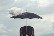 surreal moment of a cloud caressing the umbrella of a headless woman