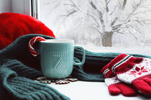 Winter Background - Cup With Candy Cane, Woolen Scarf And Gloves On Windowsill And Winter Scene Outdoors
