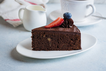 Wall Mural - Delicious Piece of chocolate cake with cup of coffee and milk on blue stone concrete table background. Breakfast food concept.