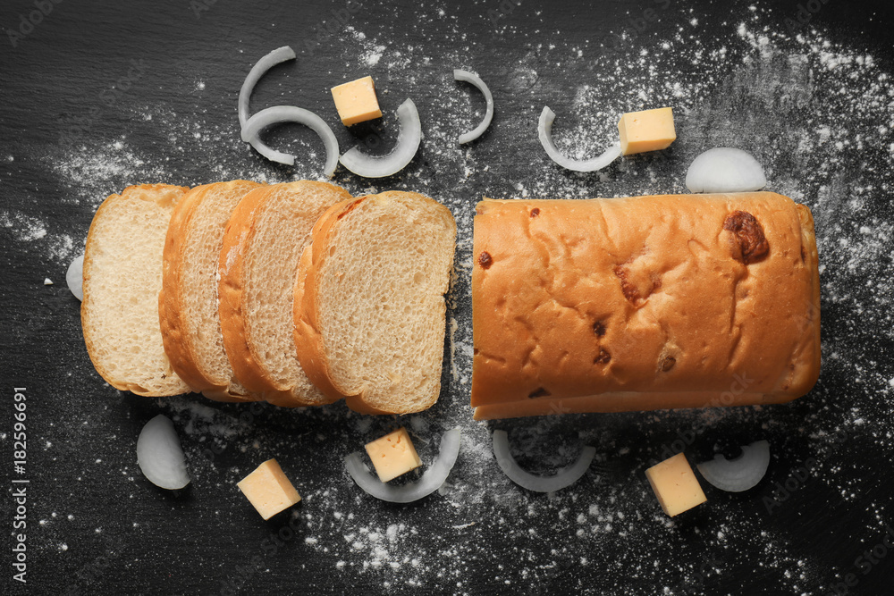 Yummy fresh bread with cheese and onion on dark background