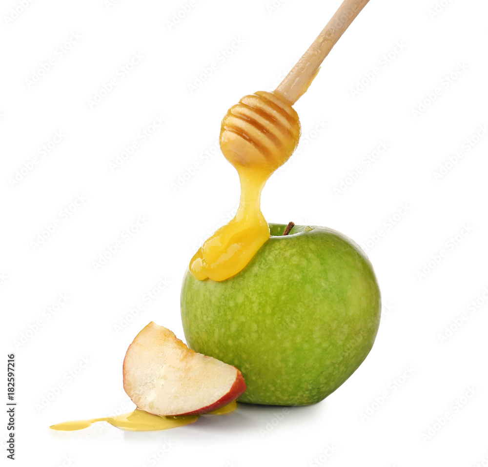 Pouring aromatic honey onto apple against white background