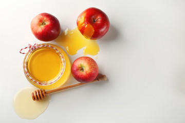 Wall Mural - Jar with aromatic honey and apples on white background