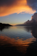 Wall Mural - Beautiful Sunset with Ocean Over-Water Bungalows and Trees in Raja Ampat Indonesia