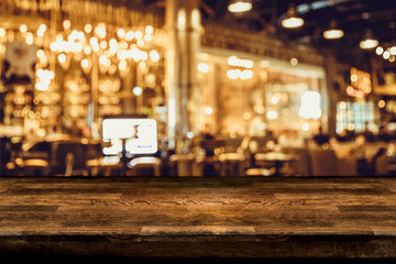 Wall Mural - Empty wood table top and blur of night pub or restaurant background/selective focus .For montage product display