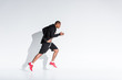© LIGHTFIELD STUDIOS - side view of young african american sportsman in sportswear running on grey