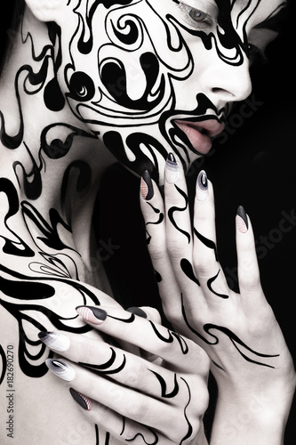 Beautiful girl with art black and white makeup and nails. Creative beauty face. Photo taken in the studio. © Kobrinphoto