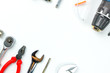 © Goodvibes Photo - Top view of Working tools,wrench,socket wrench,hammer,screwdriver,plier,electric drill,tape measure,machinist square and safety glasses on white background.flat lay design