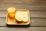 Fototapeta Kuchnia - lemon black tea in glass cup on wooden table