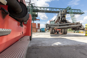 Zwei rote Hubstapler im Containerhafen nebeneinander