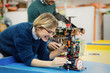 © NDABCREATIVITY - Young woman engineer working on robotics project