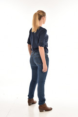 Sticker - Full length portrait of a girl wearing simple blue shirt and jeans, standing pose facing away on a white background.