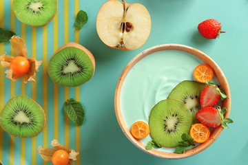 Poster - Bowl with yummy spirulina smoothie and bottle of drink on wooden table. Healthy vegan food concept