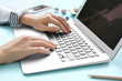 © Africa Studio - Woman using laptop on blue table
