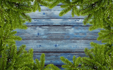 frame of fir branches on blue wood