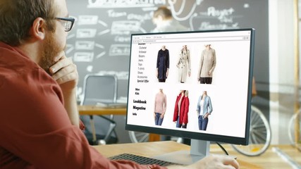 Wall Mural - web designer works on a website for online retail clothing store. he and colleagues work in stylish 