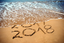 New Year 2018 Is Coming Concept - Inscription 2017 And 2018 On A Beach Sand, The Wave Is Covering Digits 2017. New Year 2018 Celebration On New Year`s Eve Tropical Island Travel Tour.