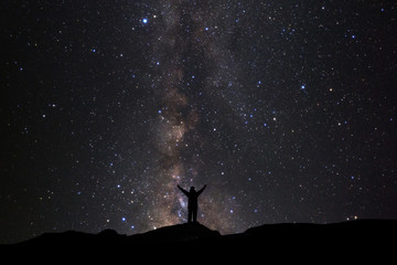 Wall Mural - landscape with milky way, night sky with stars and silhouette of man standing on high moutain